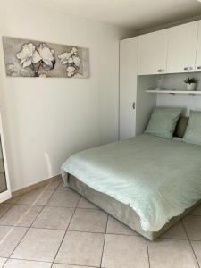 罗克布吕讷-卡普马丹Cap d.Azur的卧室配有一张床,墙上挂有绘画作品