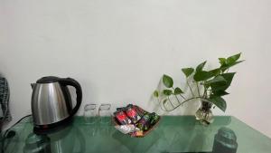 高平Green Riders House的茶壶和玻璃桌上的花瓶