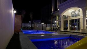 吉赞نزل خيال للشقق المخدومه的一座游泳池,在晚上在建筑物前
