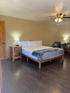 派托普湖畔木场小屋宾馆的一间卧室配有一张带两张桌子的床和吊扇。