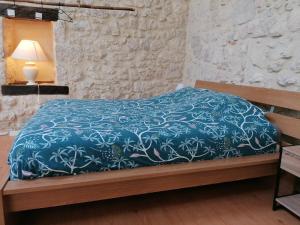 卡斯泰勒雅卢LE LOFT的一间卧室配有一张带蓝色棉被的床