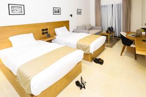 开罗NewCity Hotel & Suites的酒店客房配有两张床和一张书桌