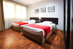 开罗NewCity Hotel & Suites的配有2张床的酒店客房,铺有木地板