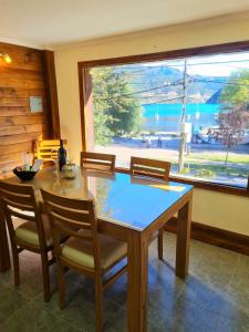 圣马丁德洛斯Puerto Lacar Lodge SMARG的一间带桌椅和大窗户的用餐室