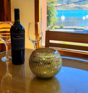 圣马丁德洛斯Puerto Lacar Lodge SMARG的一瓶葡萄酒和一杯酒在桌子上