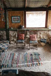 米茨佩·拉蒙萨卡沙漠旅舍的客厅配有两把椅子和地毯。