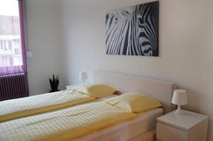 巴塞尔Rent a Home Landskronstrasse - Self Check-In的卧室配有一张床,墙上挂有绘画作品