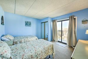 北怀尔德伍德Beachfront North Wildwood Condo with Ocean Views!的蓝色的客房设有两张床和窗户。