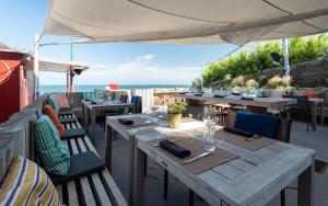 圣马洛阿尔恩尼兹酒店的餐厅设有桌椅,以大海为背景