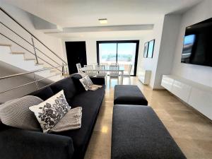 波多黎各Villa Playa Amadores - Luxury villa with heated pool的客厅配有黑色沙发和桌子