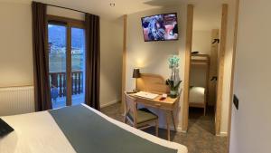 欧苏瓦Village de vacances Fleurs et Neige的配有一张床、一张书桌和一扇窗户的酒店客房