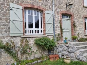 Saint-Amand-JartoudeixBon Chez Nous的石屋,带绿门和石墙