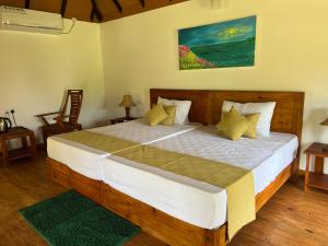 蒂瑟默哈拉默Saffron Lake Yala的一间卧室配有一张带黄色枕头的大型木制床。