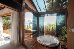 塞尔苏拉穆斯州长镇Ponta dos Ganchos Exclusive Resort的甲板上设有按摩浴缸的房间