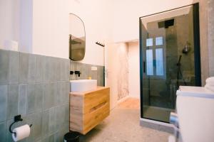 柏林The Weinert Suites的浴室配有盥洗盆和带镜子的淋浴