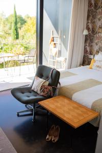 普罗旺斯艾克斯哈隆旅馆的酒店客房设有椅子、床和阳台