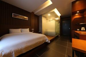 清州市Sejong City Osong Hotel的一间带白色大床的卧室和一间浴室