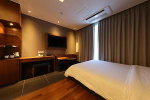 清州市Sejong City Osong Hotel的配有一张床和一张书桌的酒店客房