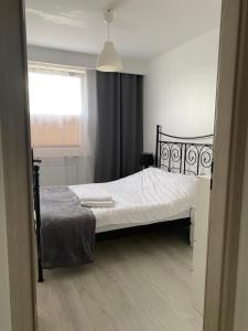 比亚瓦波德拉斯卡Apartament Żeromskiego的一间卧室配有一张带白色床单的床和一扇窗户。