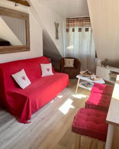乌弗奈特弗斯Appartement Chalet Pra Loup的客厅配有红色的沙发和椅子