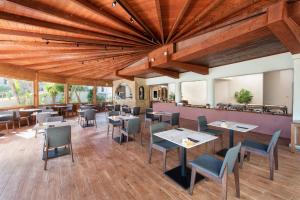 依克希亚Ixia Dream hotel - Adults only的餐厅设有木制天花板和桌椅