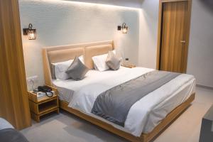 艾哈迈达巴德Hotel The Grand Crystal的一间卧室配有带白色床单和枕头的床。