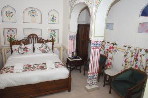 布什格尔KothiPushkar的一间卧室配有一张床和一把椅子