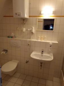 于克里茨Hotel Ratscafe Ückeritz的白色的浴室设有卫生间和水槽。