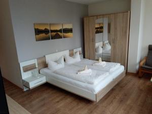 于克里茨Hotel Ratscafe Ückeritz的卧室配有一张白色大床和镜子
