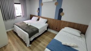 巴拉奈里奥-坎布里乌Pousada Al Mare的一间小卧室,配有两张床和窗户