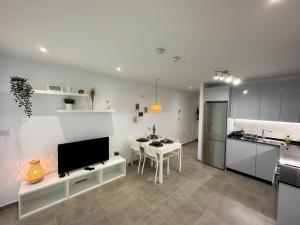 直布罗陀Brand New - Massive Studio - E1 - Self Catering的厨房以及带桌子和电视的客厅。