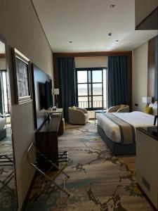 利雅德Rosa Grand Hotel的酒店客房,配有床和电视