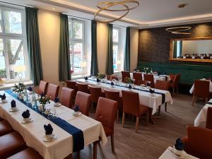 森夫滕贝格Parkhotel Senftenberg的餐厅设有长桌子、椅子和窗户。