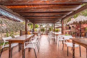 Charco del Pino朱利亚娜酒店的配有木桌和白色椅子的餐厅