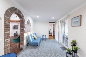 北岭Spacious Home with Garden & Pool的客厅设有蓝色的沙发和砖墙