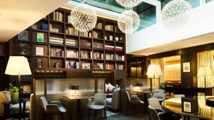 米兰米兰斯伽拉酒店的一间带桌椅和书架的餐厅