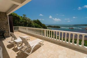 CalibishieOceanfront 3-bedroom villa with spectacular view!的阳台上配有两把椅子和一张桌子,享有海景