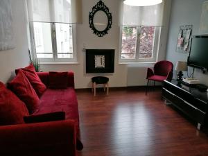 斯特拉斯堡Appartement 3 pièces, Krutenau, Parking privé的客厅配有红色沙发和电视