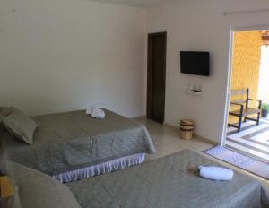 巴拉格兰德Pousada Viva Barra的酒店客房设有两张床和电视。