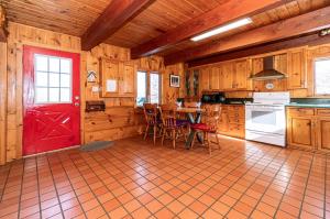 Algonquin HighlandsPine Springs Retreat with Hot Tub Steam Room Lake Kushog的厨房设有红色的门和桌椅