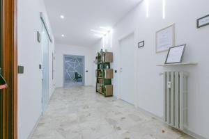 雷焦艾米利亚Alle Porte Del Centro - Guest House - Reggio Emilia - Ingresso Centro Storico - Parcheggio Gratuito的走廊设有白色墙壁和瓷砖地板