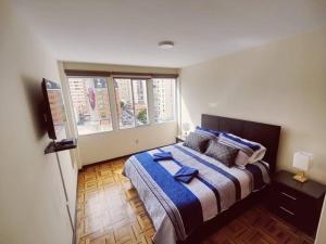 拉巴斯Cómodo, amplio y céntrico apartamento en Sopocachi的一间卧室设有一张床和一个大窗户