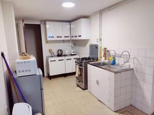 拉巴斯Cómodo, amplio y céntrico apartamento en Sopocachi的厨房配有白色橱柜和炉灶烤箱。