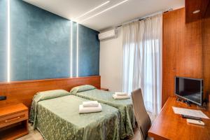 罗马米勒罗斯酒店的酒店客房设有两张床、一张桌子和一台电视。