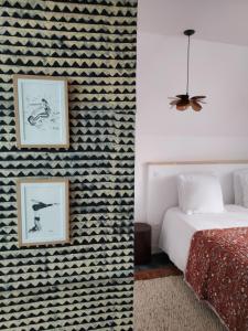 圣库隆Maison Triton et Porcelaine的卧室配有带图案的墙壁,毗邻一张床