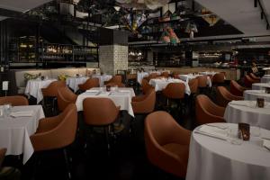 悉尼悉尼QT精品酒店的一间设有白色桌椅的用餐室
