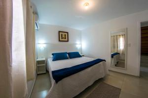 格拉瓦塔尔Pousada Gravatá的一间卧室配有一张带蓝色枕头和镜子的床