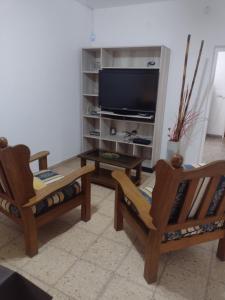 圣罗莎Casa en Santa Rosa的客厅配有2把椅子和平面电视