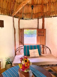 TzucacebEncantadora Villa Maya tradicional en Rancho Agroecologico的一间设有两张床的房间和一张鲜花桌子