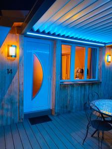 梅塔比耶Au-Doux-Altic chalet romantique avec JACUZZI ET SAUNA的天井配有桌子和蓝色的灯光